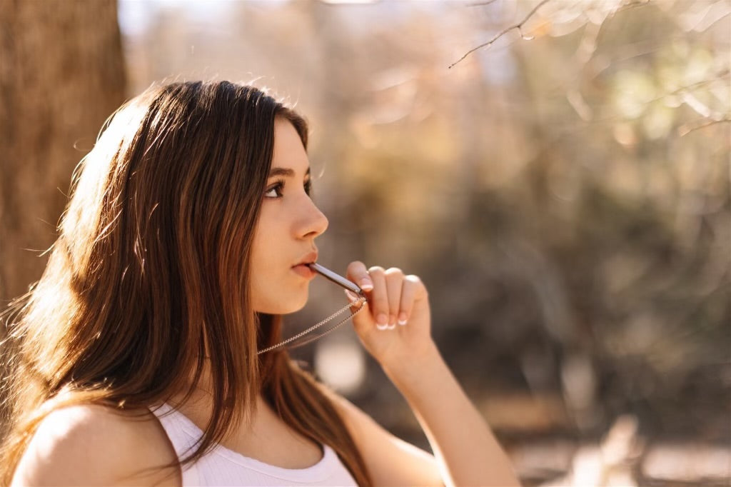 girl using silver breathing necklace for stress relief